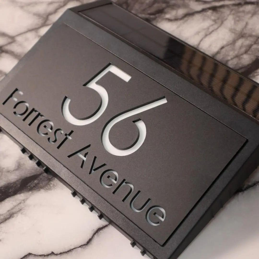 Modern custom acrylic house sign with engraved address number 56 and Forrest Avenue on a marble surface