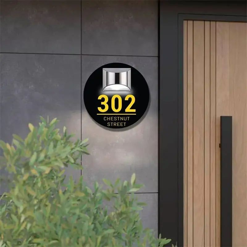 Round black solar-powered acrylic house sign with yellow address number 302 and Chestnut Street text mounted outdoors