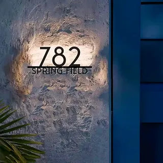 House number '782 Springfield' on a textured wall with a blue door.