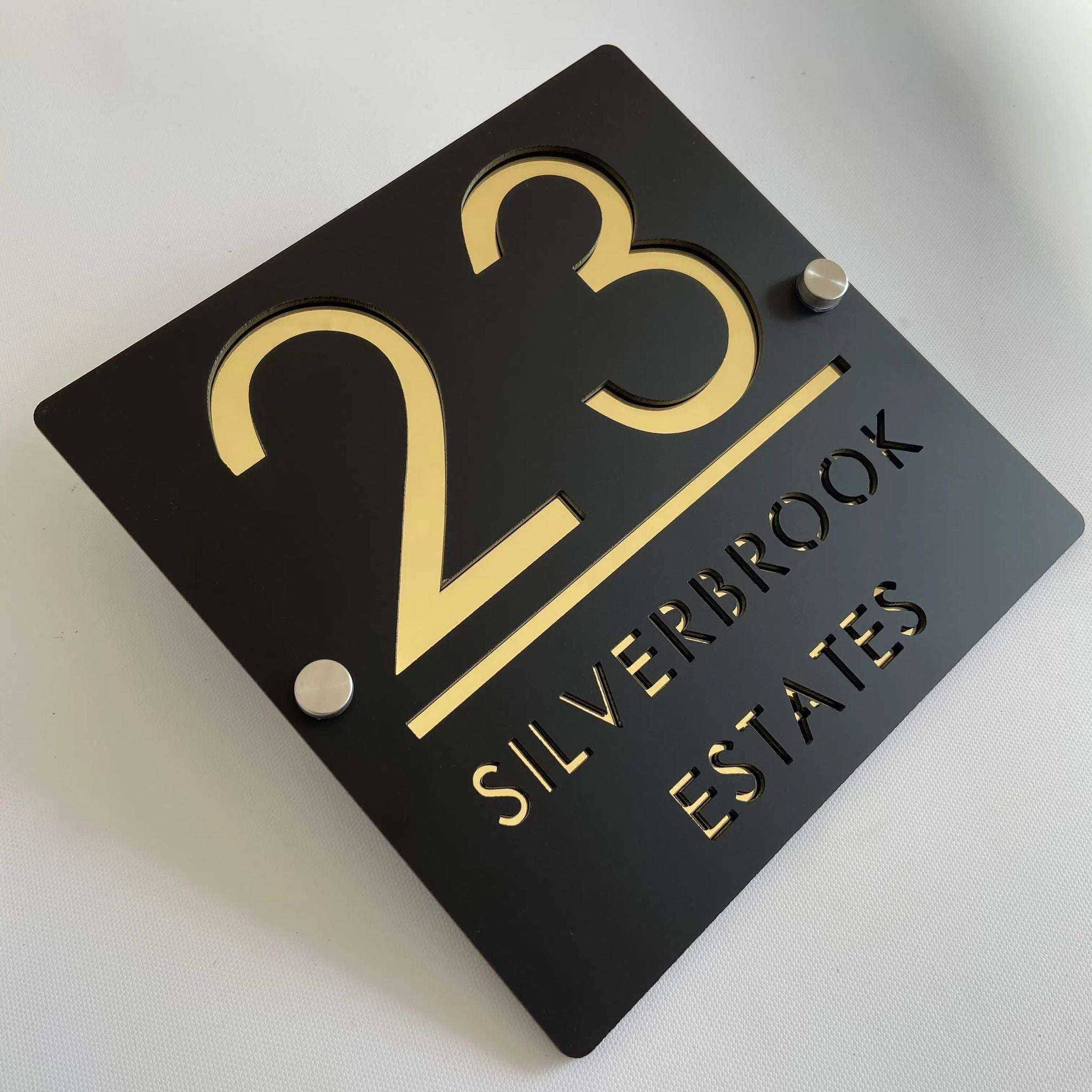 Custom black acrylic house plaque with gold numbers 23 and Silverbrook Estates text on standoffs, square design.