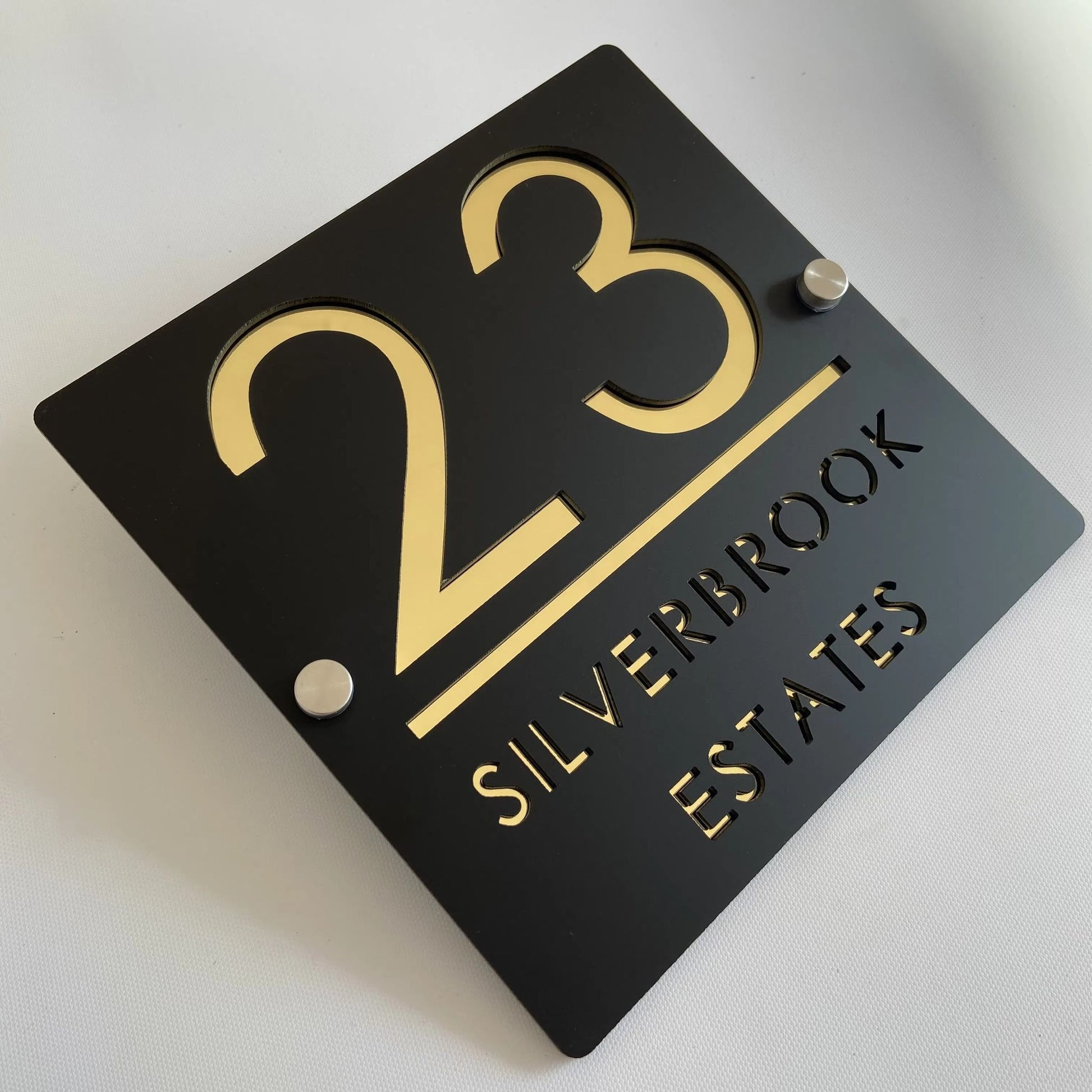 Custom black acrylic house plaque with gold numbers 23 and Silverbrook Estates text on standoffs, square design.