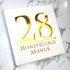 Square custom acrylic house sign with gold number 28 and Honeysuckle Avenue text on white background