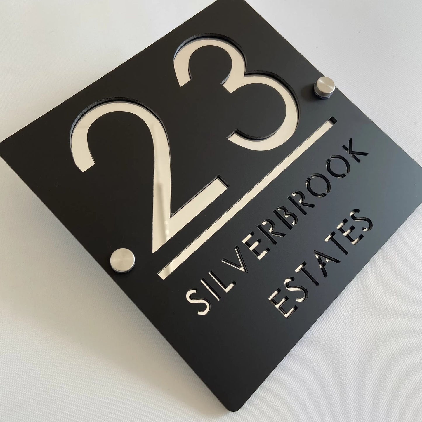 Custom black acrylic square house plaque with number 23 and text Silverbrook Estates on standoffs