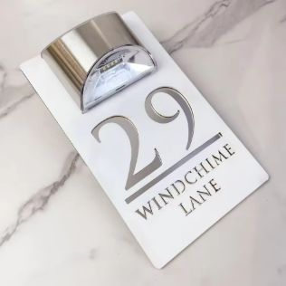 White rectangular custom acrylic house sign with silver laser-etched address and solar LED light on top