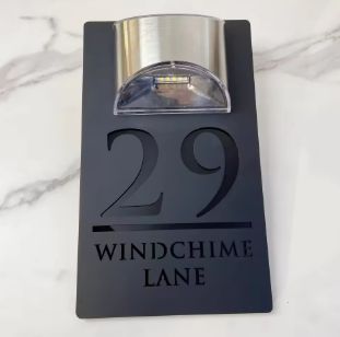 Custom black acrylic rectangular house sign with solar light, engraved number 29 and Windchime Lane address.