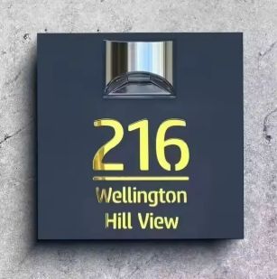 Square solar-powered acrylic house sign with illuminated custom address and street name mounted on wall