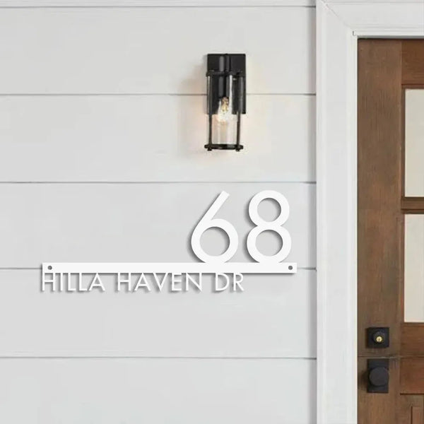 Custom modern floating house number plaque with raised white numbers and street name on grey shiplap siding next to wooden door