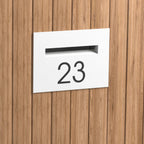 white mailbox installed in a timber fence with the number 23
