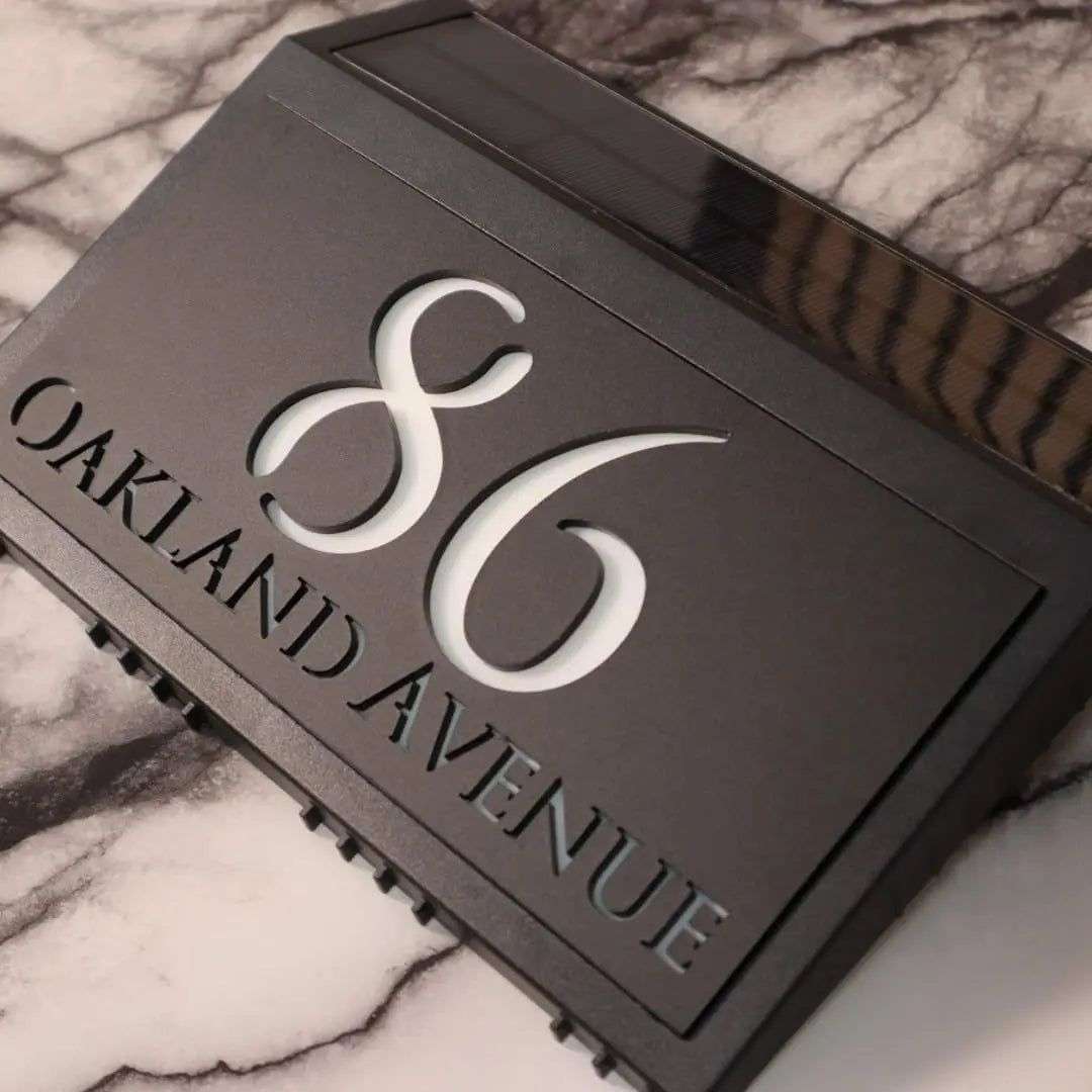 Modern solar-powered custom acrylic house sign with laser-etched address numbers and text on black panel