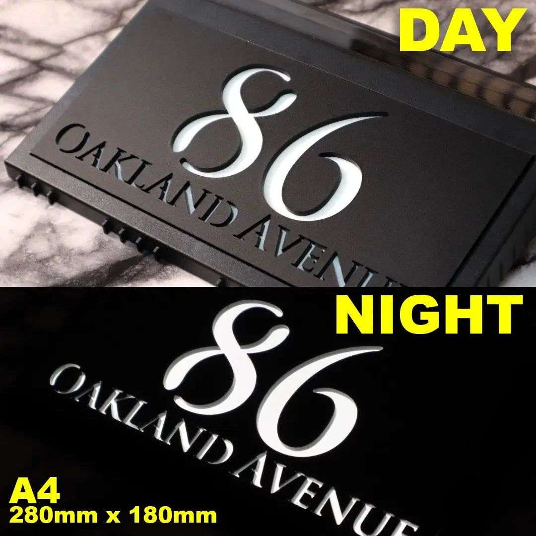 Custom solar acrylic house sign displaying 86 Oakland Avenue with illuminated numbers at night.