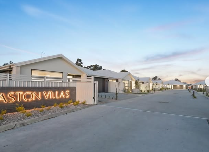 Modern villas with 'ASTON VILLAS' sign at sunset
