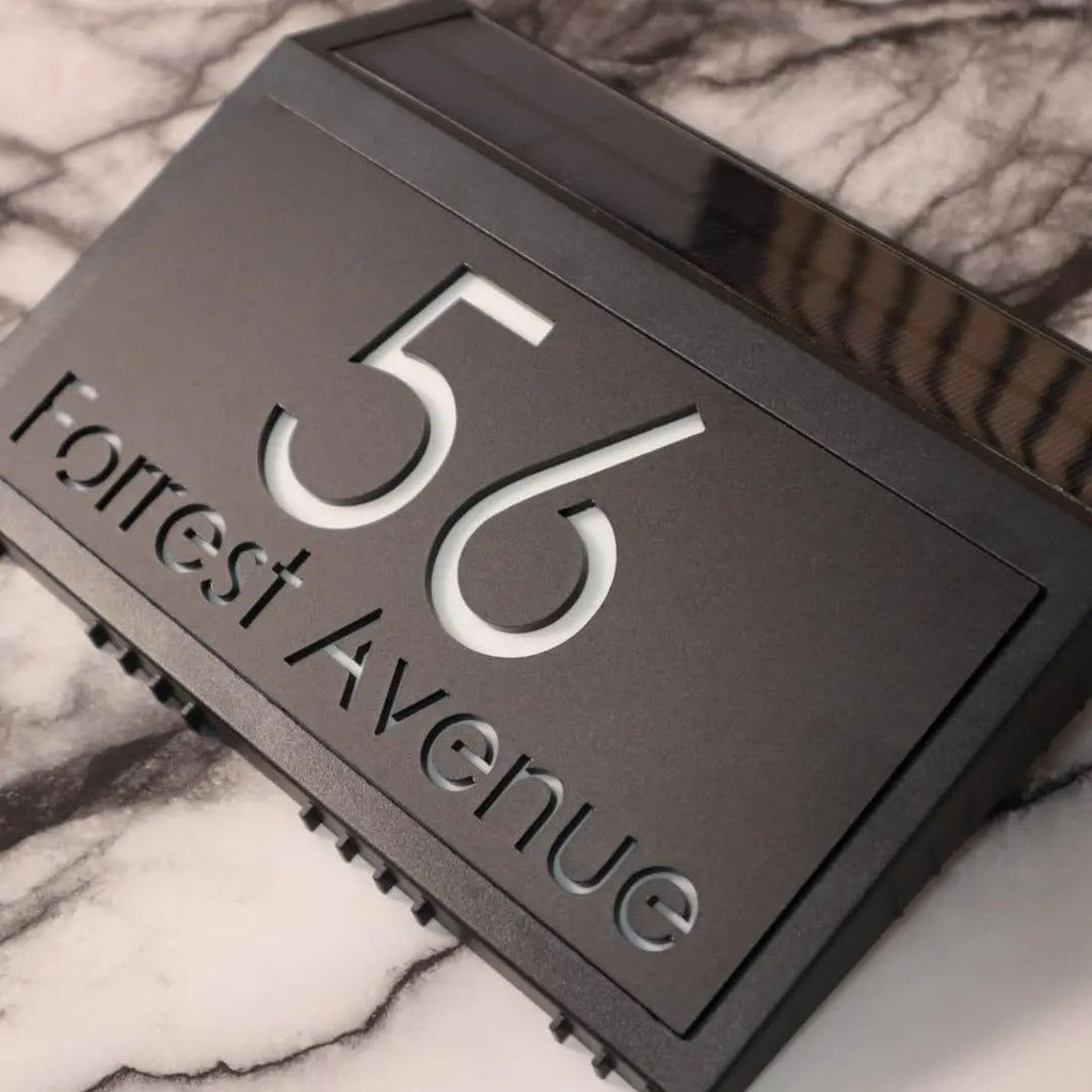 Modern custom acrylic house sign with engraved address number 56 and Forrest Avenue on a marble surface