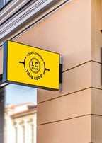 Rectangular yellow acrylic LED lightbox sign mounted on beige building exterior displaying custom logo.