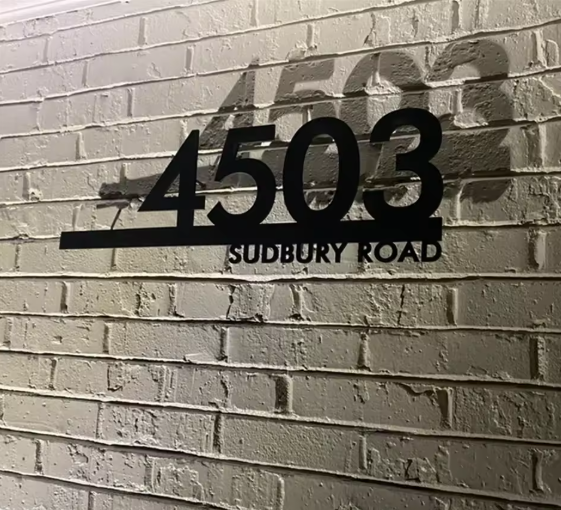 Address sign on a brick wall with '4503 Sudbury Road' text.