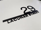 Custom modern floating house number plaque with black raised 29 and Lacunar Street text on white background